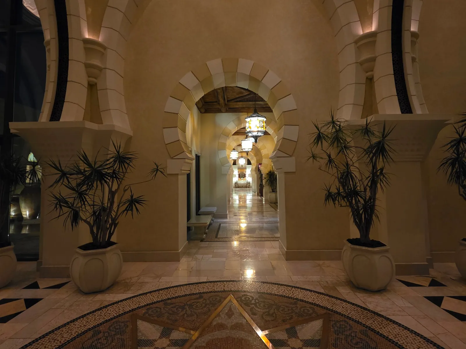 Arched marble gallery in a Dubai hotel, softly lit with lanterns