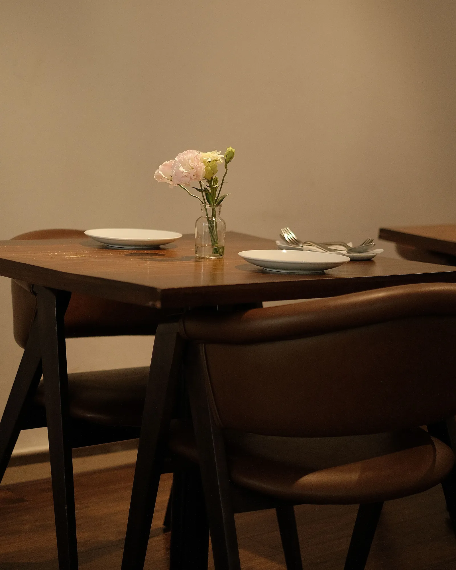 Table set for a private dinner, with a single flower