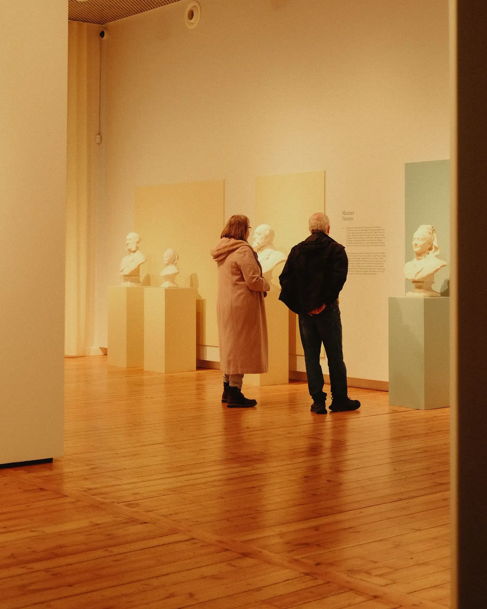 Guests at a private viewing in a softly lit gallery